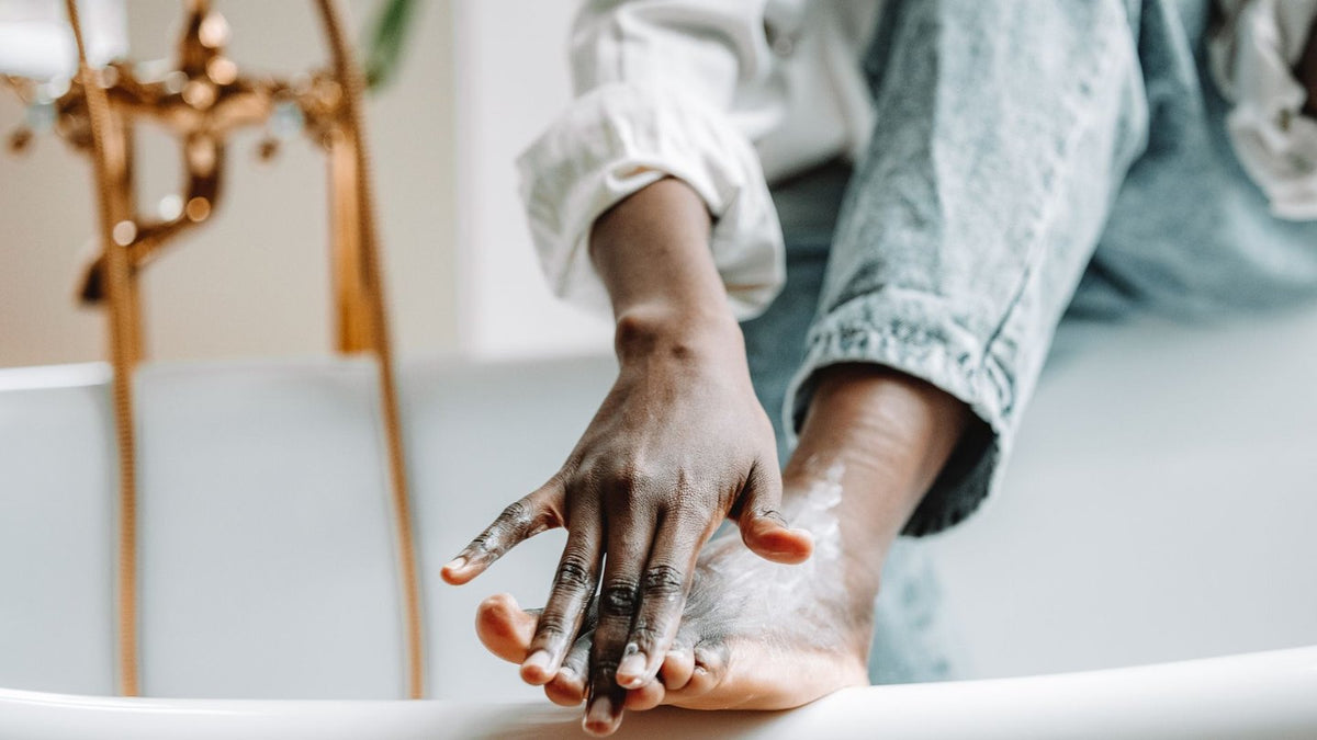 Applying moisturizing cream to dry feet and heels