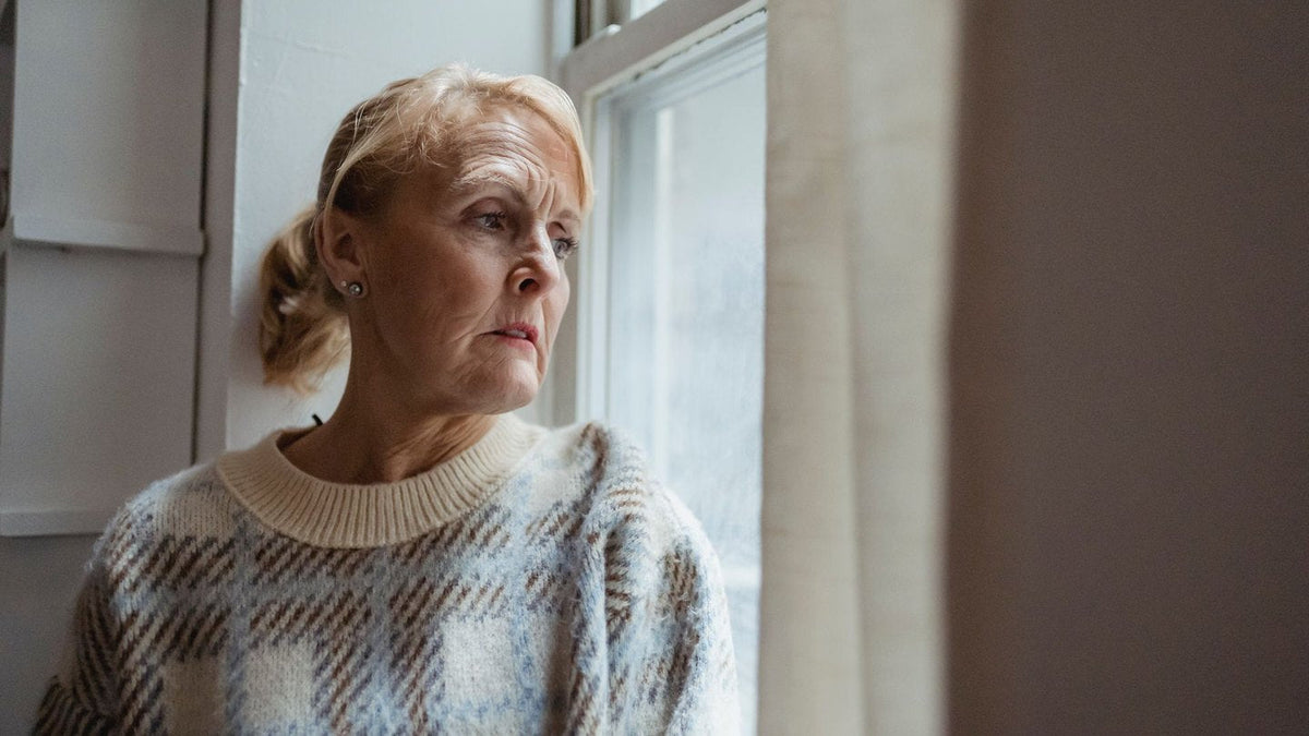 Thoughtful mature woman sitting by a window
